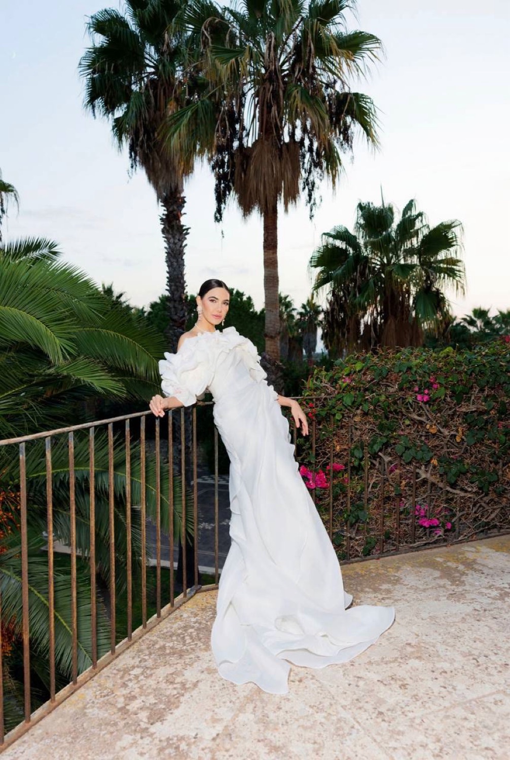 Bride in a flowing gown among palm trees